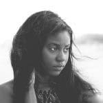 Thoughtful young woman with long hair looking away